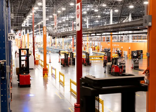 Distribution associate operating forklifts inside The Home Depot Canada distribution centre.