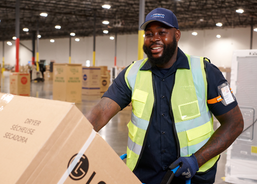 The Home Depot Canada field associate handling appliance delivery in a warehouse environment.